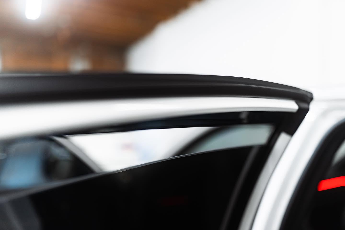 Close-up of a clean tinted windshield brow on a white car