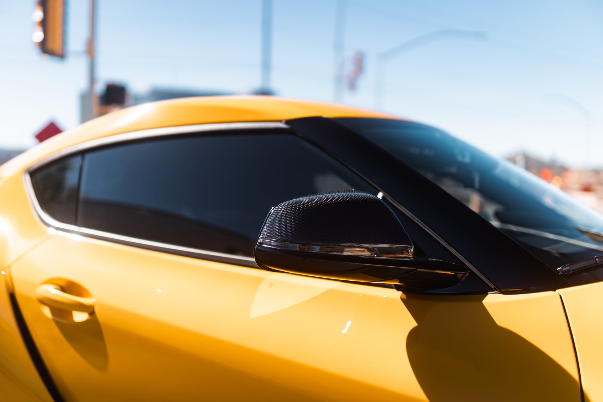 Yellow sports car with dark window tint parked under the Arizona sun